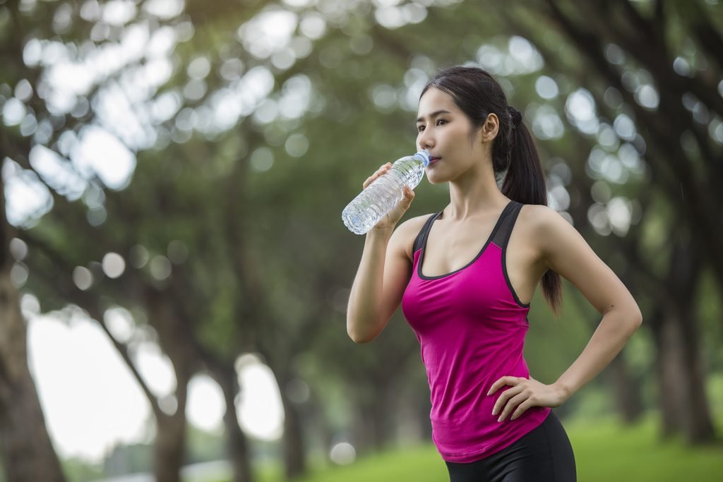 woman drinking water when exercising