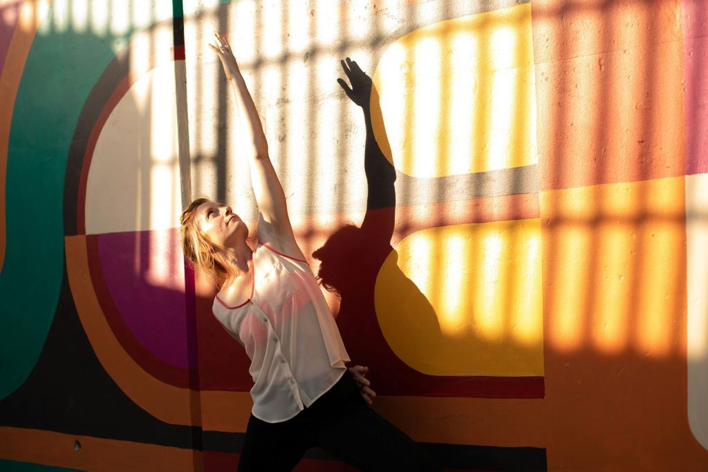 woman stretching in front of colorful wall