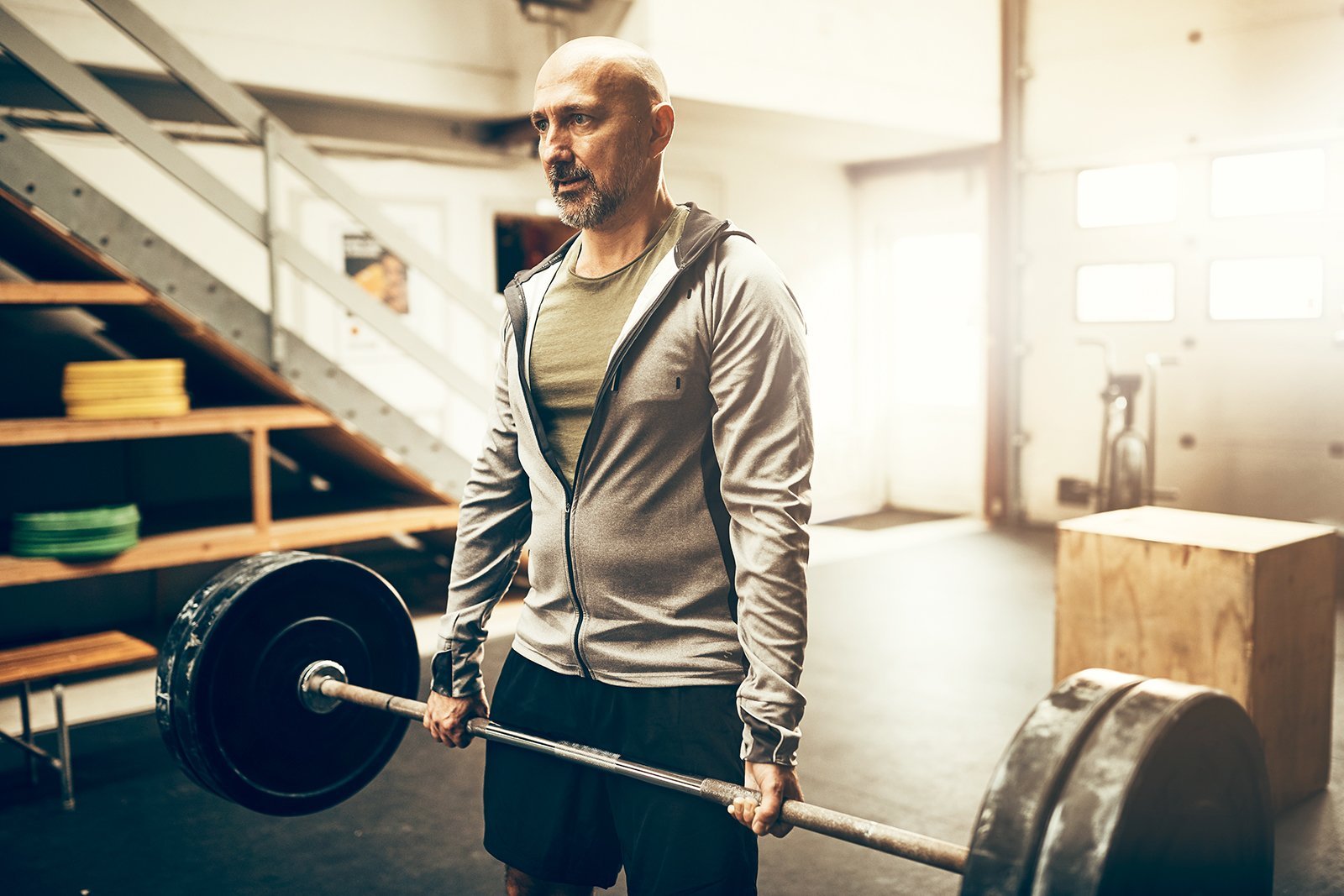 older man deadlifting heavy barbell after testosterone replacement therapy trt